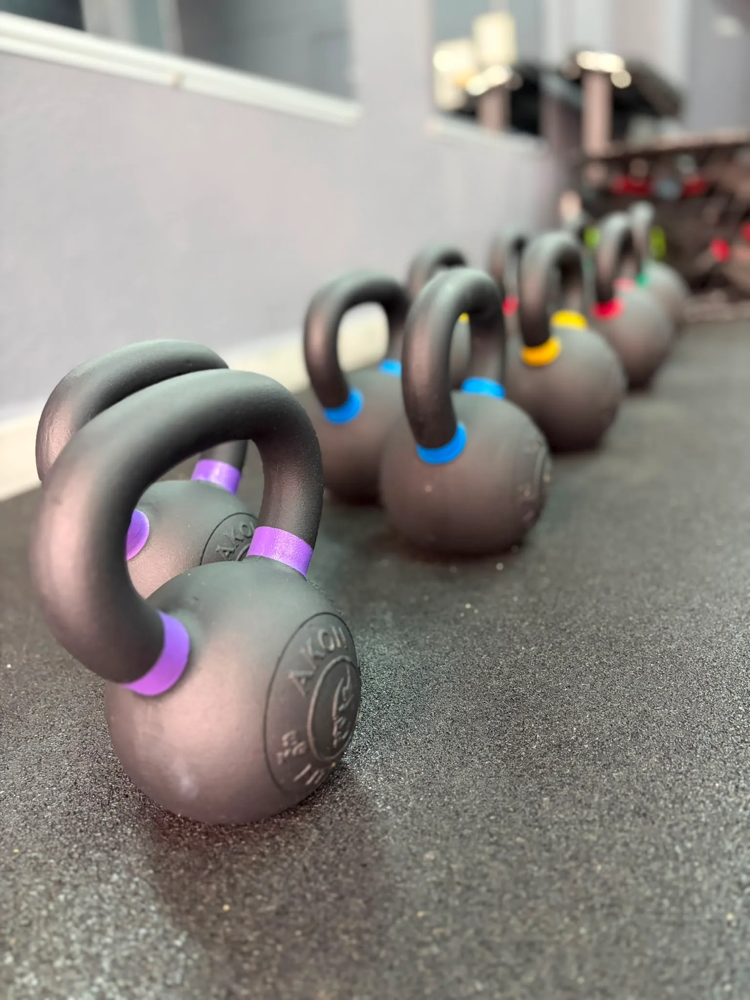 Kettlebells alineadas en la sala de entrenamiento de Mencey Studio